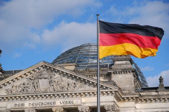 Reichstagsgebäude in Deutschland mit Blick auf die Kuppel, davor eine wehende Deutschlandflagge - Foto: tvjoern / pixabay.com